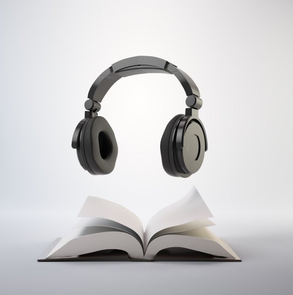 Open book with a headphone set - audiobook concept