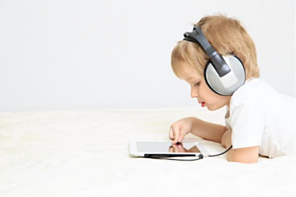 Dziecko z słuchawkami i tabletem