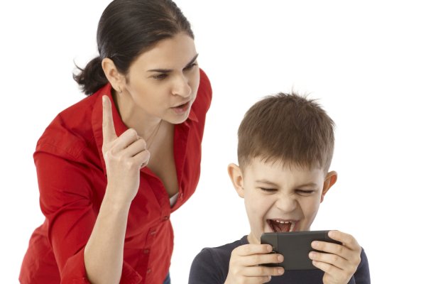 Little boy playing on mother's mobilephone, mother rebuking him