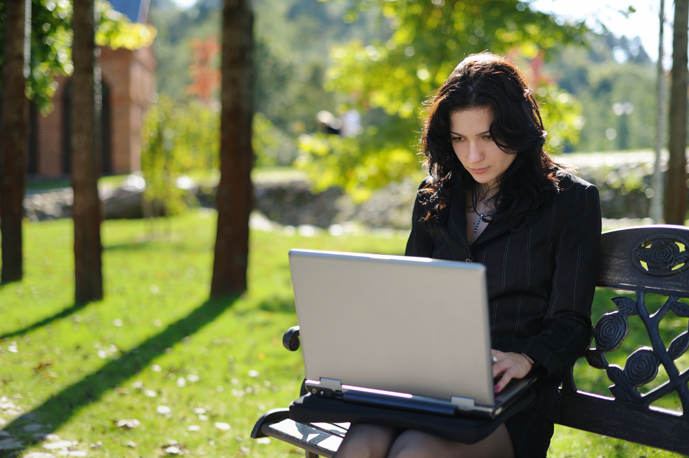 Kobieta korzystający z Wi-Fi w parku, fot. shutterstock.com