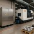Nowoczesna stacja transformatorowa w obudowie metalowej stojąca obok zaawansowanej maszyny CNC marki Mazak w hali produkcyjnej
